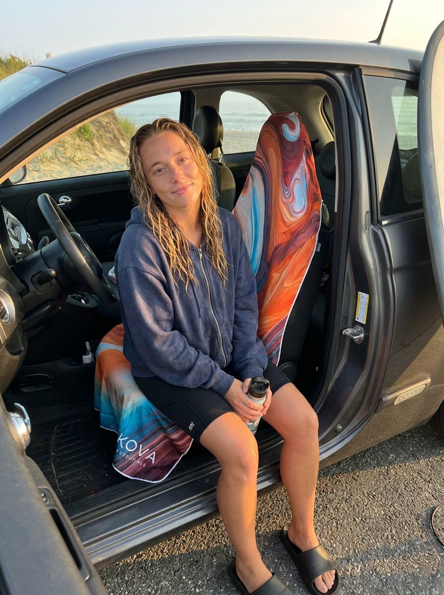 Surfer sitting on the Orange KOVA towel in her car at the beach